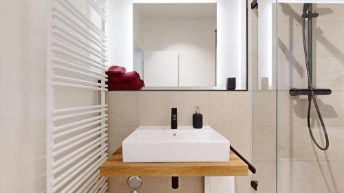 a bathroom with a white sink and a shower at Apartment 02 No 8A Boardinghouse Lüneburg in Lüneburg