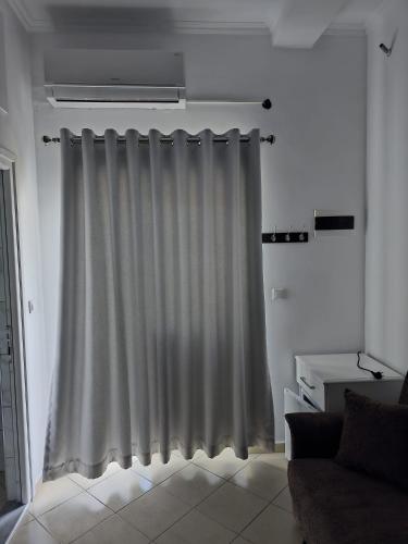a white curtain in a living room with a couch at Saranda Landscape in Nivicë