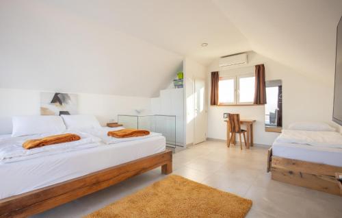 a bedroom with two beds and a table at Awesome Home In Aljmas With Sauna in Aljmaš