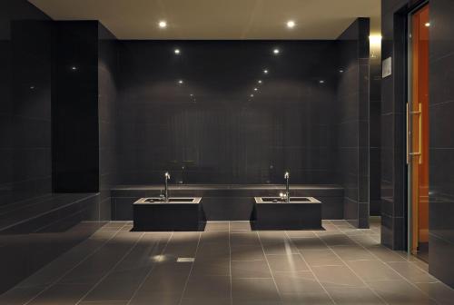 a bathroom with two sinks and black walls at Radisson Blu Hotel Zurich Airport in Kloten