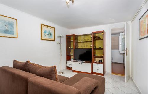 a living room with a couch and a television at 1 Bedroom Cozy Apartment In Kraljevica in Kraljevica