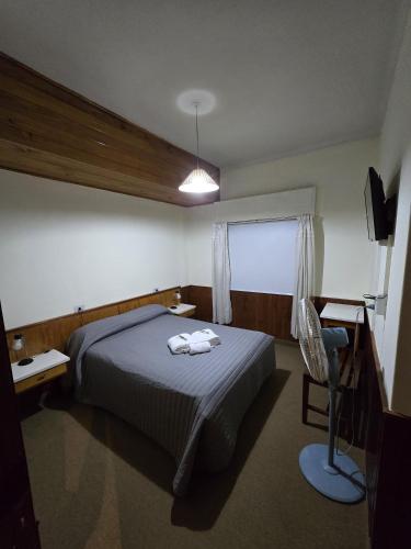 a bedroom with a bed with two towels on it at Hotel Punto Sur Avenida in Malargüe