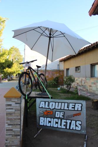 a bike parked on a sign with an umbrella at Hotel Punto Sur Avenida in Malargüe