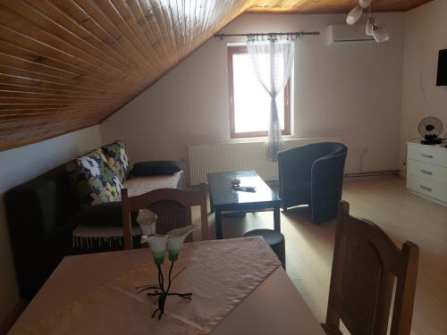 a living room with a table and a couch at Djokić 2 sa bazenom in Soko Banja