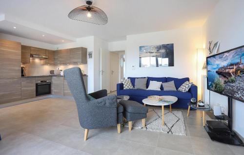 un salon avec un canapé bleu et une table dans l'établissement 3 Bedroom Cozy Apartment In Saint-Malo, à Saint-Malo