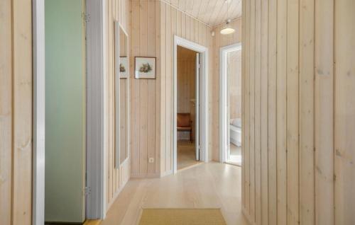 a hallway with wood paneled walls and a doorway at Nice Home In Højby With House Sea View in Højby