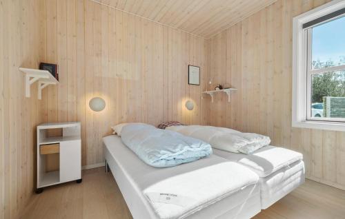 a bedroom with a bed with white sheets and a window at Nice Home In Højby With House Sea View in Højby