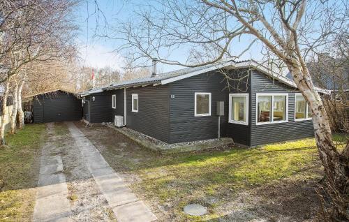 a black house with a driveway in front of it at 3 Bedroom Pet Friendly Home In Korsør in Korsør