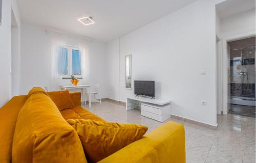 a living room with a yellow couch and a television at Awesome Apartment In Novalja With Wifi in Novalja