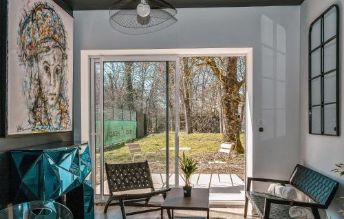 - un salon avec une porte en verre donnant sur une terrasse dans l'établissement Suite Charmilles Avec Piscine, à Gien