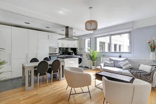 un salon avec un canapé, une table et des chaises dans l'établissement Appartement spacieux - Arc de Triomphe, à Paris
