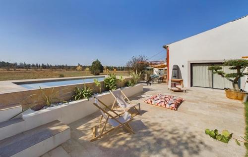 une terrasse avec une chaise et une piscine dans l'établissement Beautiful Home In Eyragues With Wifi, à Eyragues