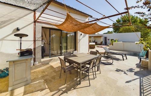 un patio avec une table, des chaises et un barbecue dans l'établissement Beautiful Home In Eyragues With Wifi, à Eyragues
