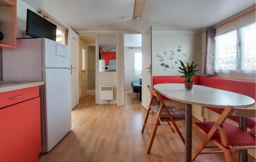 Il comprend une petite cuisine avec une table et un réfrigérateur blanc. dans l'établissement Mobilhome With Shared Pool, à Carnac