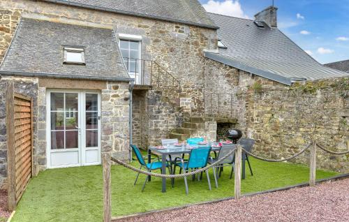 a patio with a table and chairs in front of a building at Lovely Home In Hauteville-Sur-Mer in Hauteville-sur-Mer
