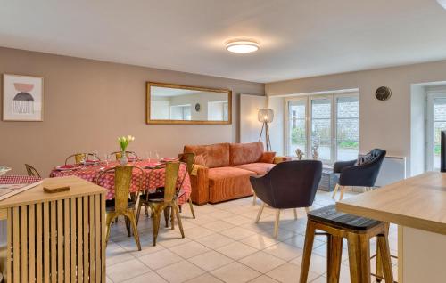 un salon avec une table et un canapé dans l'établissement Lovely Home In Hauteville-Sur-Mer, à Hauteville-sur-Mer