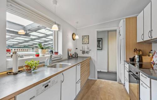 a kitchen with white cabinets and a sink at Beautiful Home In Viby Sjælland in Dåstrup
