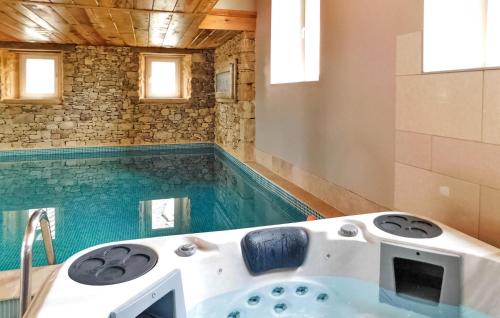 La salle de bains est pourvue d'une piscine et d'une baignoire. dans l'établissement Awesome Home In La Chapelle-Aubareil, à La Chapelle-Aubareil