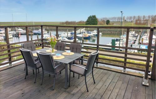 a table and chairs on a deck with a marina at 3 Bedroom Nice Home In Stavenisse in Stavenisse