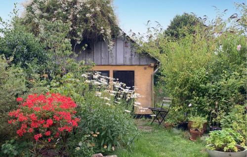 a garden with a building with a bunch of flowers at 2 Bedroom Stunning Home In Tranekær in Tranekær
