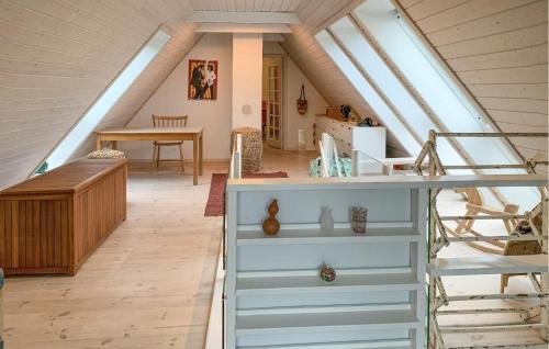 a attic room with a desk and a table at 2 Bedroom Stunning Home In Tranekær in Tranekær