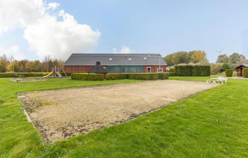 a barn with a playground in front of a grass field at 2 Bedroom Nice Home In Wagenborgen in Wagenborgen