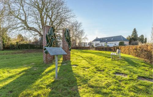 a sign in a field with a house in the background at 2 Bedroom Nice Home In Wagenborgen in Wagenborgen