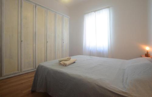 Un dormitorio blanco con una cama y una ventana. en Beautiful Apartment In Piombino, en Piombino