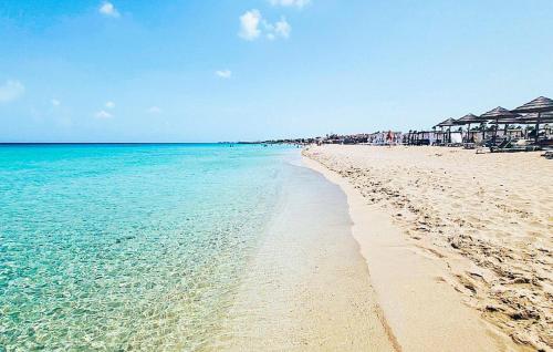 a beach with turquoise water and houses on it at Residenza Flamingo in Marzamemi