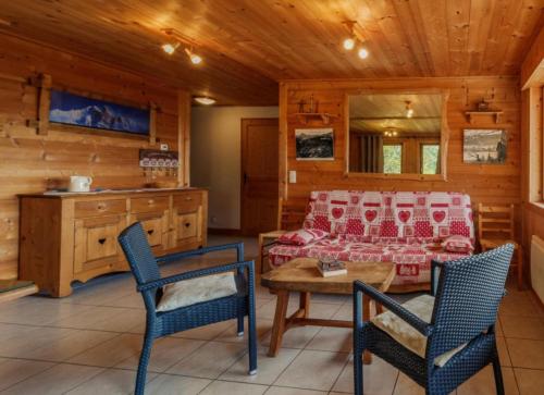 - un salon avec un canapé et des chaises dans une cabine dans l'établissement La dent de Cons, à Notre-Dame-de-Bellecombe