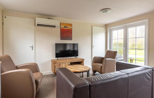 un salon avec un canapé, des chaises et une télévision dans l'établissement 3 Bedroom Gorgeous Home In Wagenborgen, à Wagenborgen