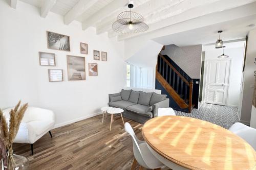 un salon avec une table et un canapé dans l'établissement Maison de standing - 50m des plages - Jacuzzi, à Ploemeur