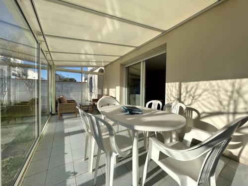 une table blanche et des chaises sur une terrasse dans l'établissement Mais 3 pièces Oléron 6 couchages - DOLUS D'OLERON DDO000-114, à Dolus-d'Oléron