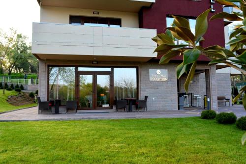 a building with tables and chairs in front of it at Victoriya's House in Hisarya