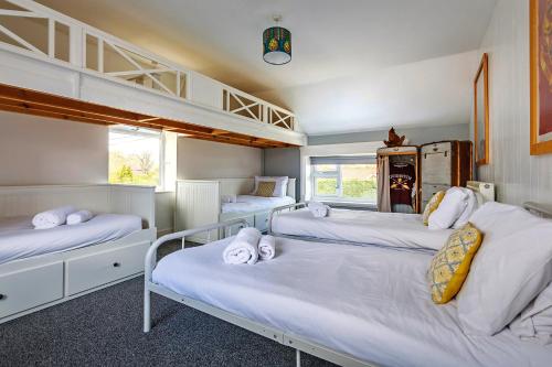 a bedroom with three bunk beds and two bunkunks at Finest Retreats - The Stables at Crimplesham in Stradsett