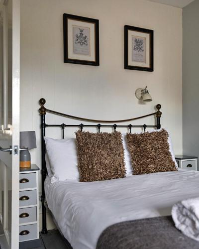 a bedroom with a bed with two pictures on the wall at Finest Retreats - The Stables at Crimplesham in Stradsett