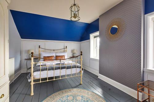 a bedroom with a blue ceiling and a bed at Finest Retreats - The Stables at Crimplesham in Stradsett