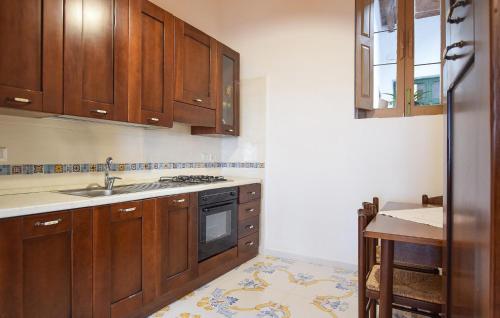 a kitchen with wooden cabinets and a sink at Amazing Home In Frazione Cosentini in Cosentini