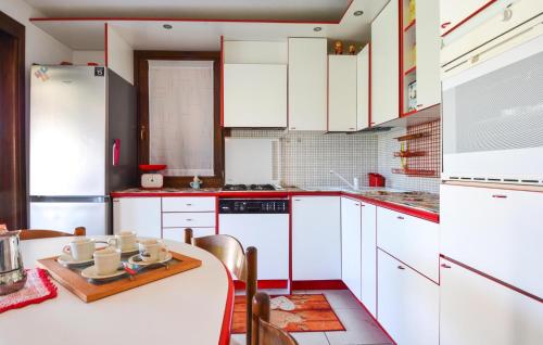 a kitchen with white cabinets and a table with chairs at Cozy Home In Torre Dei Corsari in Torre Dei Corsari