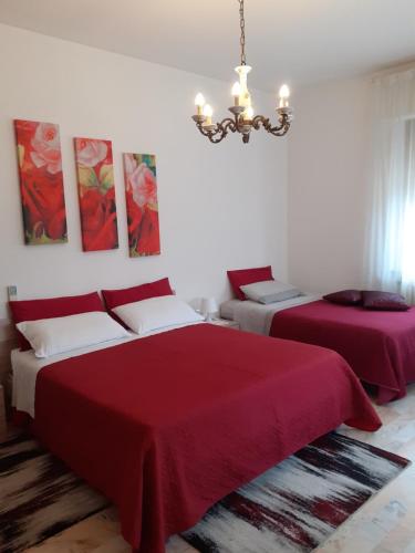 una camera da letto con due letti e un lampadario di Casa Dilva a Porto SantʼElpidio