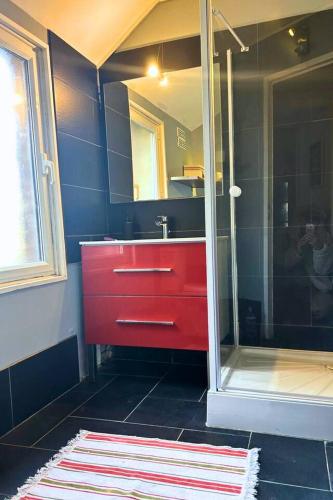 La salle de bains est pourvue d'un lavabo rouge et d'une douche. dans l'établissement Les Gîtes de Pronleroy Longère de Charme Évasion Nature et Jacuzzi, à Pronleroy