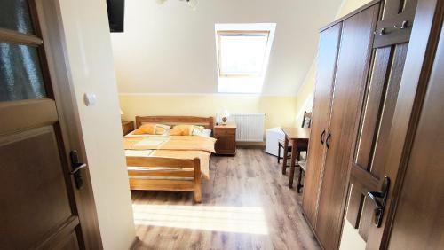 a bedroom with a bed and a table and a window at Jaś i Małgosia nad Jeziorem Wigry in Rosochaty Róg