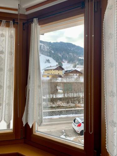 a window with a view of a snow covered mountain at Appartamento FedElia a Tarvisio vicino al centro in Tarvisio