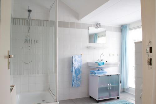 y baño con ducha, bañera y lavamanos. en Apartment Boven Jan 572, en Den Helder