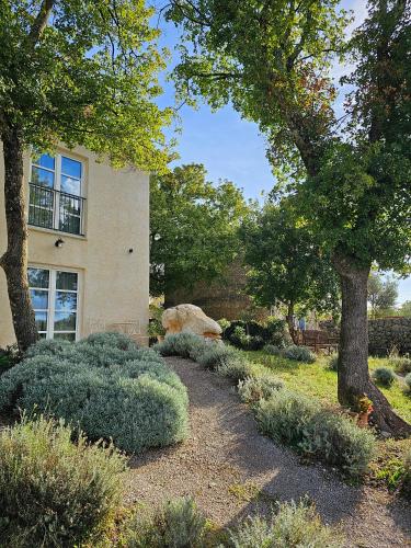 a garden with trees and bushes in front of a building at Boutique Resort OSMA - Adults Only in Malinska