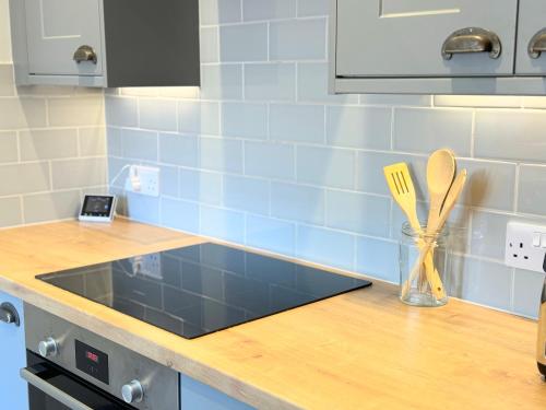 a kitchen counter with a sink and utensils in a vase at Entire Cosy Flat in Radlett - 3 Bedrooms -5 Beds - Sleeps 8 - Fast Train access into central London in Radlett
