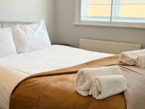 a bed with two towels on top of it at Entire Cosy Flat in Radlett - 3 Bedrooms -5 Beds - Sleeps 8 - Fast Train access into central London in Radlett
