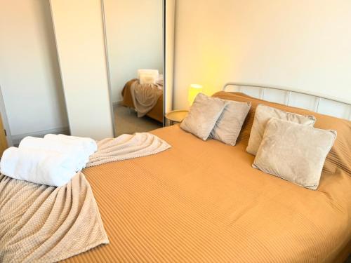 a bedroom with a bed with two pillows and a mirror at Entire Cosy Flat in Radlett - 3 Bedrooms -5 Beds - Sleeps 8 - Fast Train access into central London in Radlett