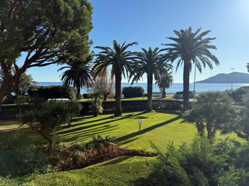 a park with palm trees and the ocean in the background at Dionysos in Cannes
