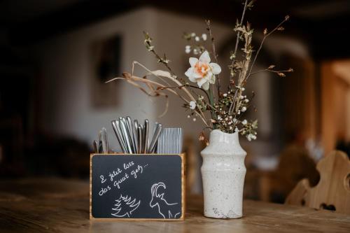 a table with a chalkboard and a vase with flowers at Forsthaus Wartenfels in Thalgau